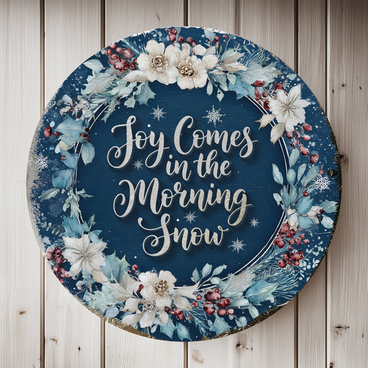 Decorative plate with floral design and text 'Joy Comes in the Morning Snow' on a wooden background